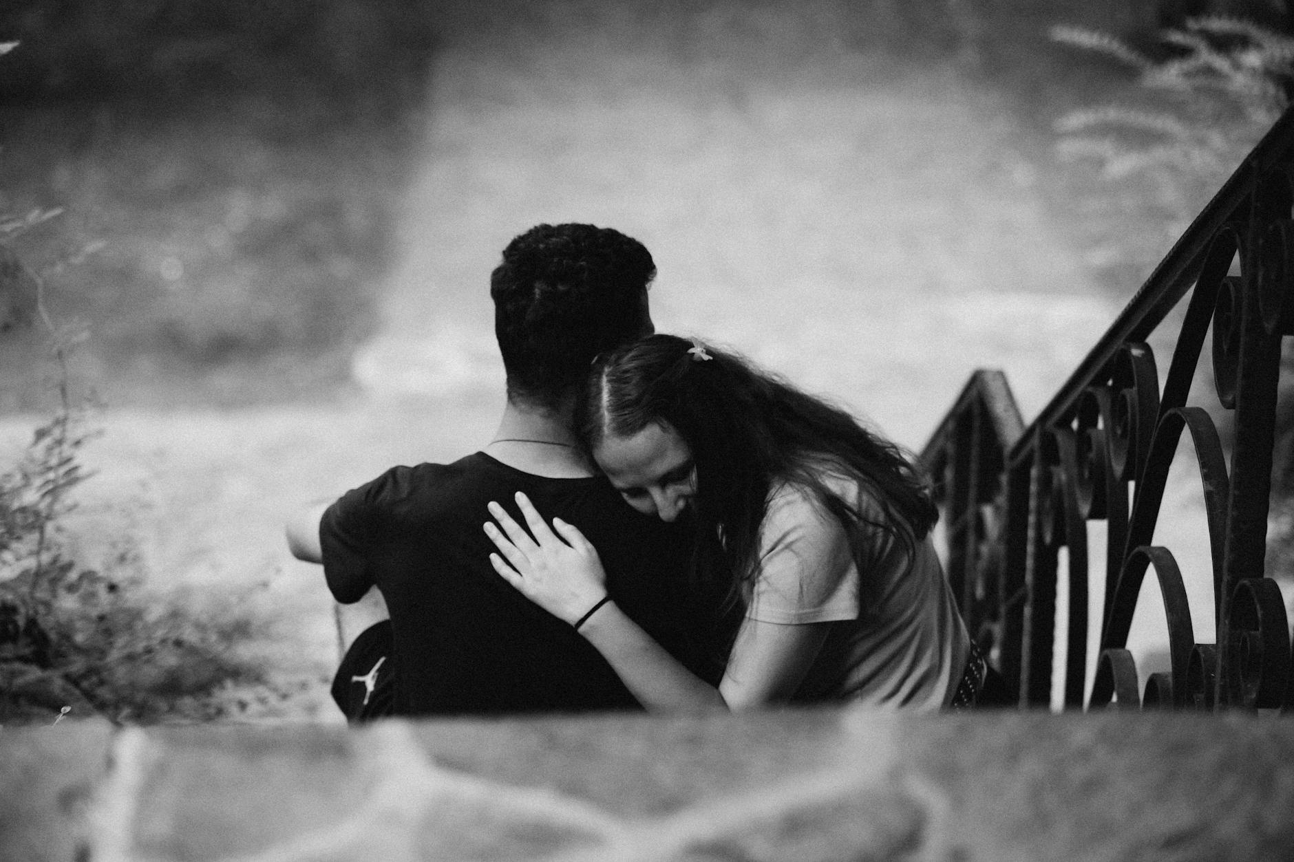 Młoda para obejmuje się czule na schodach na zewnątrz