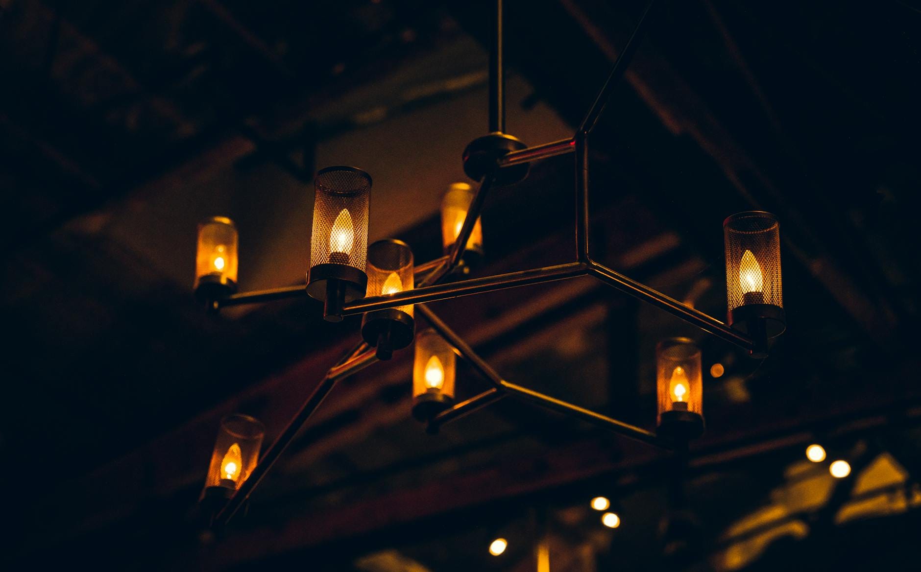 Nowoczesny żyrandol przemysłowy o ciepłym świetle w przyciemnionym wnętrzu