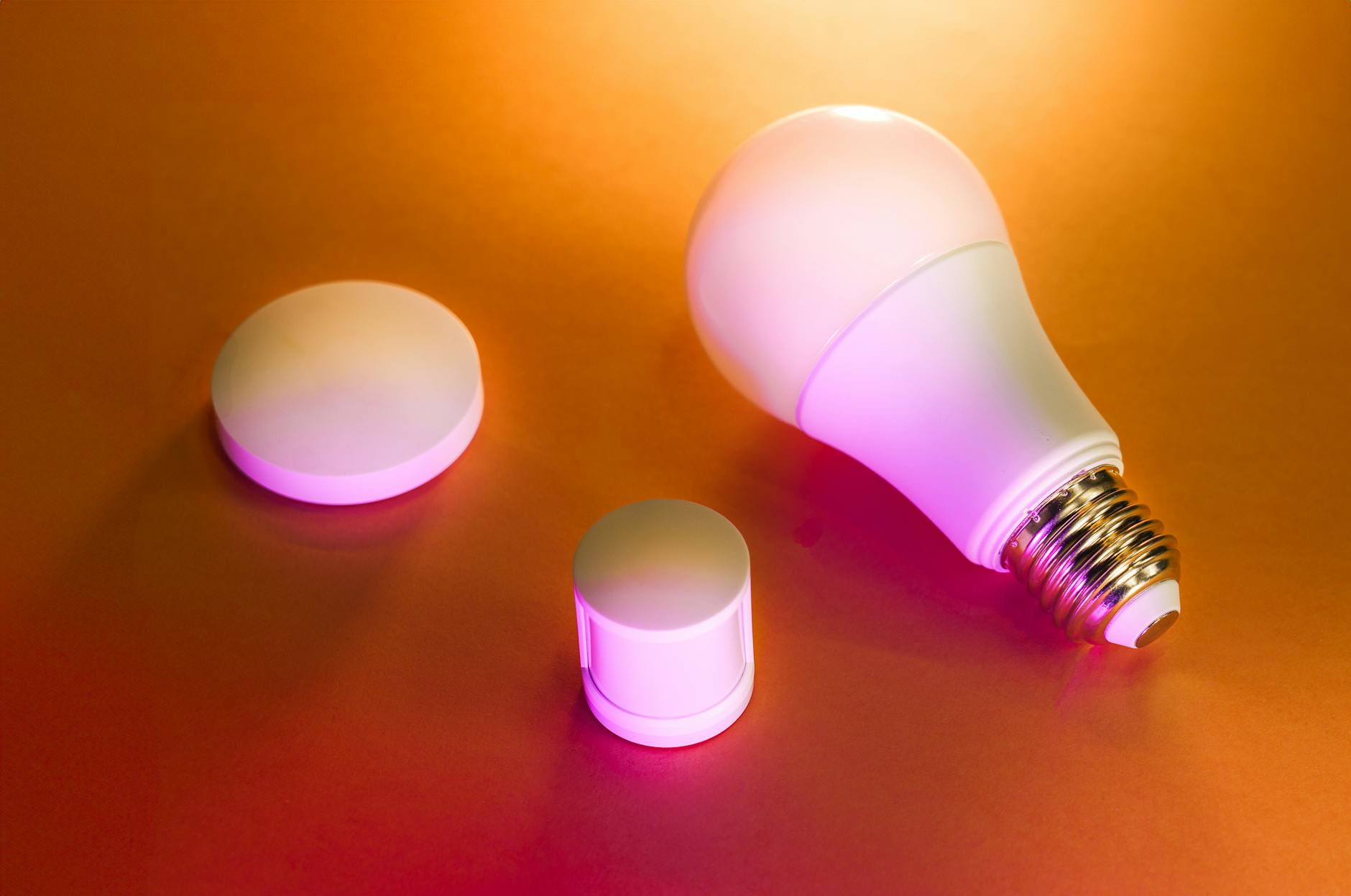 Inteligentna żarówka LED i moduły smart na pomarańczowym tle